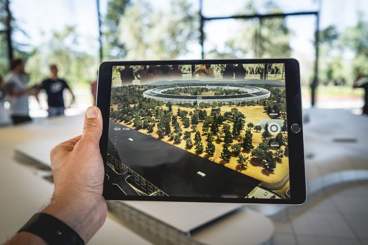 Image of a hand holding an iPad with an image displayed on it